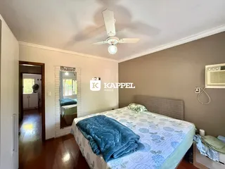Quarto com cama coberta e luminária de teto em um ambiente interno.