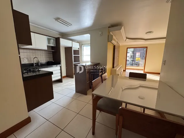 Interior de uma sala de estar com cozinha integrada em um imóvel.