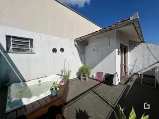 Vista externa de uma casa com uma área de piscina e um spa no pátio.
