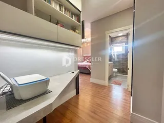 Vista interna de um ambiente com estantes embutidas e piso de madeira.