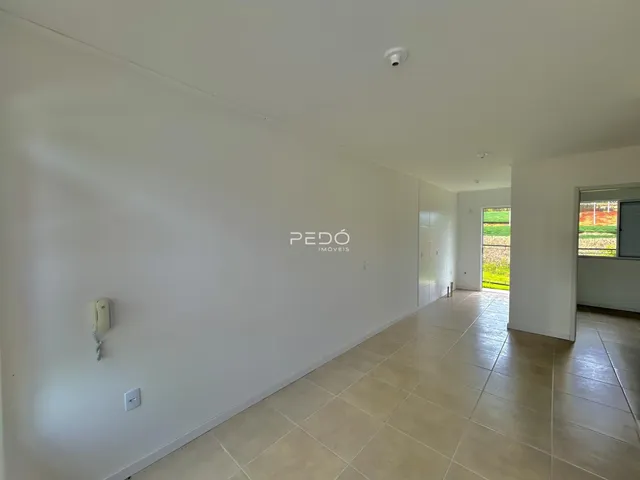 Hall de entrada com piso de cerâmica claro e paredes brancas.