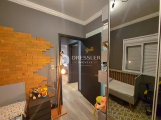 Hall de entrada com parede de tijolos aparentes e piso de madeira clara.
