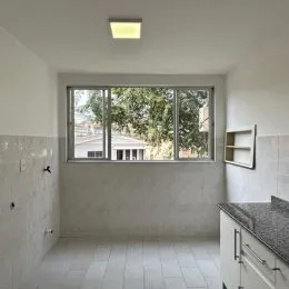 Uma sala com uma grande janela que oferece uma vista para a vegetação externa.