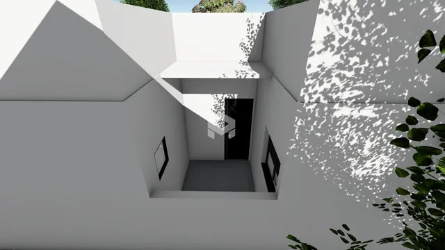 Vista interna de um espaço arquitetônico com paredes brancas e sombras marcantes.