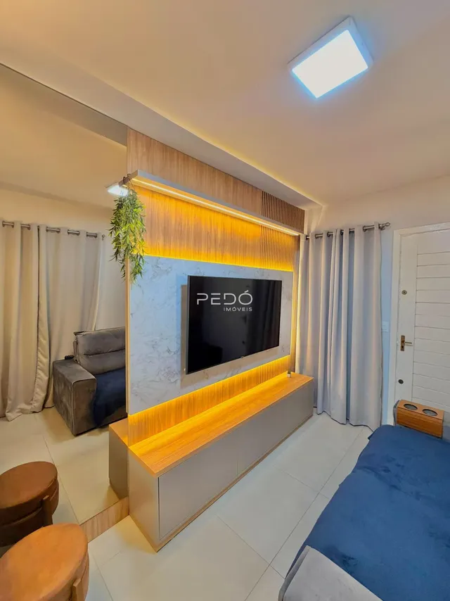 Sala de estar moderna com painel de TV e sofá em um apartamento.