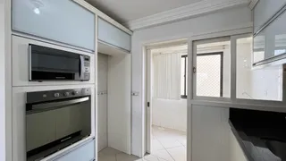 Foto de uma cozinha moderna com armários brancos e eletrodomésticos embutidos.