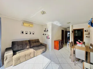 Sala de estar com sofá e piso claro.