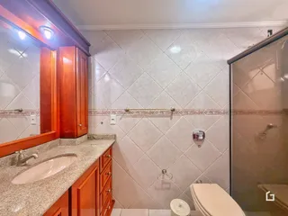 Foto de um banheiro com bancada de granito e revestimento de azulejos.