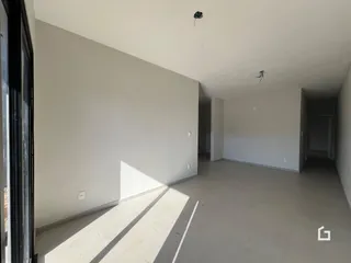 Ambiente interno amplo com paredes brancas e piso claro.
