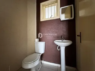 Foto de um banheiro mostrando um vaso sanitário e uma pia brancas.