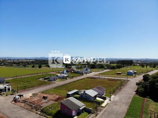 Vista aérea de uma propriedade rural com campos abertos e estruturas dispersas.