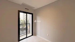Ambiente interno com porta de vidro e piso de madeira clara.