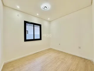 Sala de estar com piso de madeira clara e paredes brancas.