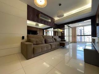 Sala de estar moderna com sofá grande e vista da cidade.