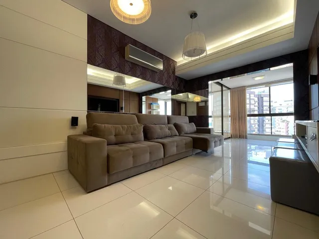 Sala de estar moderna com sofá grande e vista da cidade.