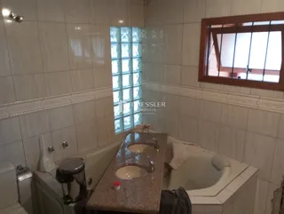 Foto de um banheiro com revestimento cerâmico claro.