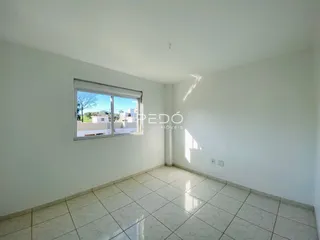 Foto de um cômodo interno com piso de cerâmica clara e paredes brancas.