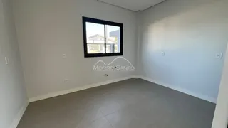 Ambiente interno com paredes brancas e uma janela grande.