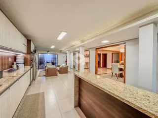 Interior de uma sala de estar com cozinha em um apartamento no Brasil.