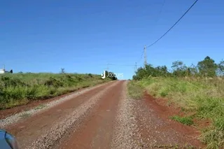 Vista de uma estrada de terra no campo sob um céu azul.