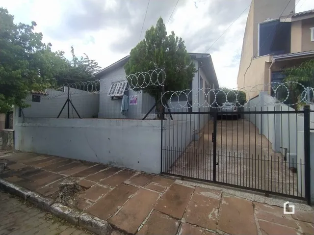 Fachada de uma propriedade com muro e cerca de ferro preta em Lajeado.