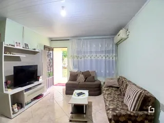 Sala de estar com sofá e televisão em um imóvel no Brasil.