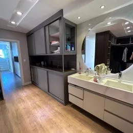 Sala de estar com piso de madeira e armários embutidos.