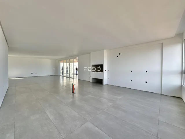 Espaço interno amplo com piso de concreto claro.