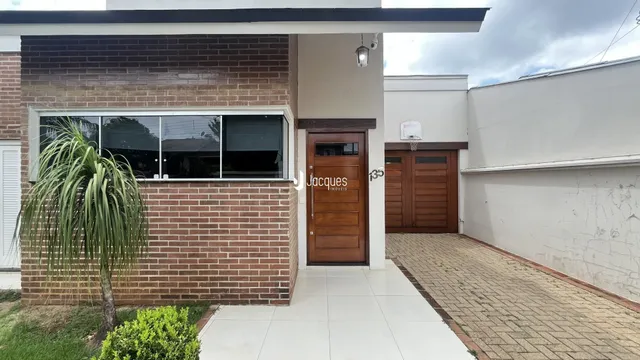 Fachada de uma residência em Lajeado, Brasil, com parede de tijolos e porta de madeira.
