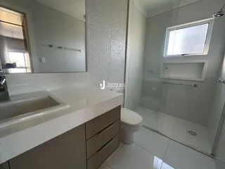 Foto de um banheiro moderno com bancada branca e box de vidro.