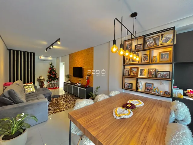 Sala de estar com sofá e mesa de jantar em ambiente moderno.