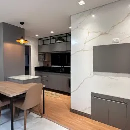 Foto de um ambiente interno com mesa de jantar e piso de madeira.