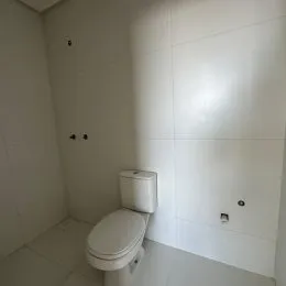 Foto de um banheiro com vaso sanitário branco.