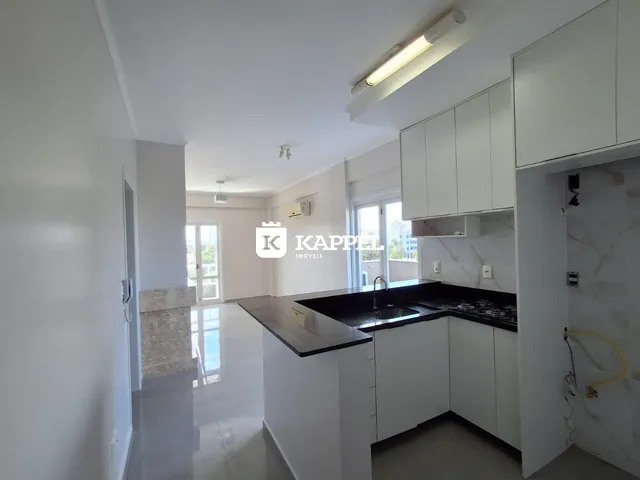 Cozinha moderna com armários brancos e bancadas escuras.