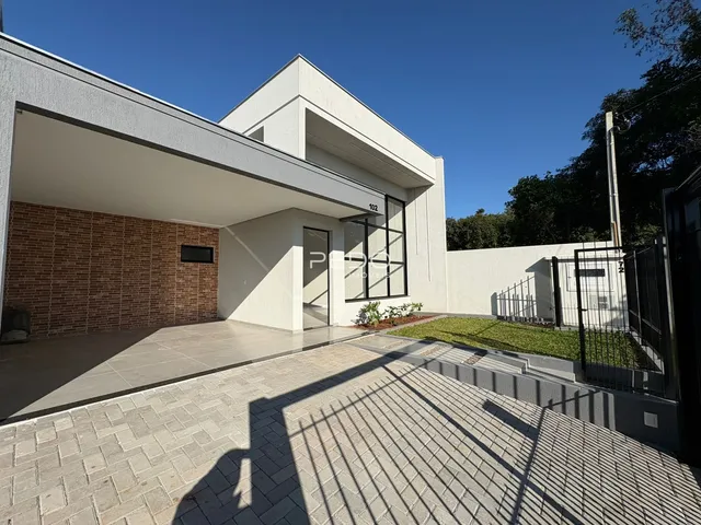 Fachada moderna de uma residência em Lajeado, Brasil, com área externa pavimentada e jardim.