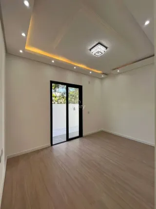 Sala de estar com piso de madeira clara e porta de vidro que dá acesso ao exterior.