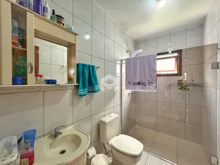 Foto de um banheiro com revestimento de azulejos brancos.