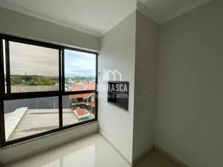 Vista interna de um cômodo com grande janela de vista para a paisagem.