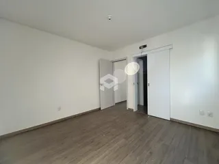 Ambiente interno de uma sala com piso de madeira clara.