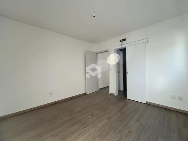 Ambiente interno de uma sala com piso de madeira clara.