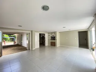 Vista interna de uma área ampla com piso de cerâmica clara.