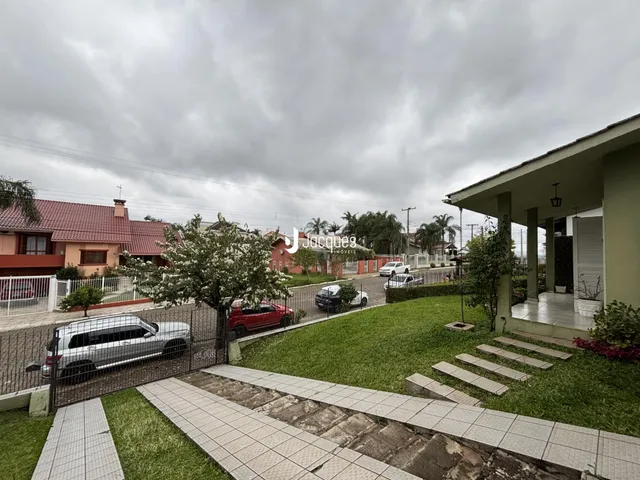 Fachada de uma casa em Lajeado, Brasil com jardim e cerca.