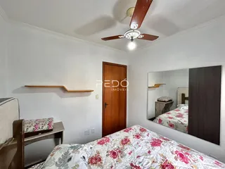 Quarto com cama e porta de madeira em um imóvel no Brasil.