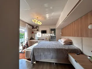 Quarto com cama grande e piso de madeira em um apartamento em Lajeado.