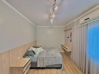 Foto de um quarto com cama e cortinas brancas.