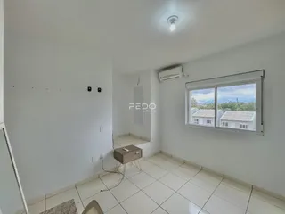 A sala apresenta paredes brancas e piso de cerâmica claro.