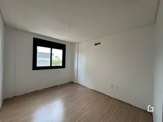 Sala com piso de madeira e janela de grande porte.