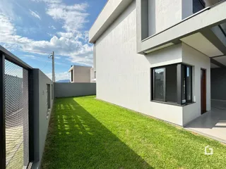 Fachada de uma casa moderna com jardim gramado em Lajeado.