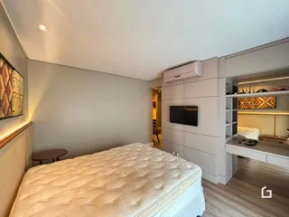 Quarto com cama estofada e armário embutido em um apartamento.