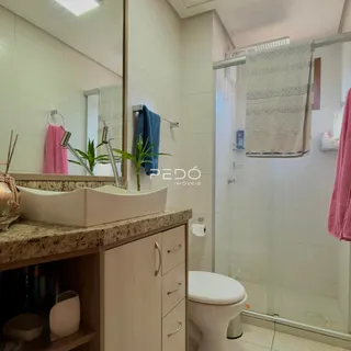 Banheiro com bancada e box de vidro em imóvel no Brasil.